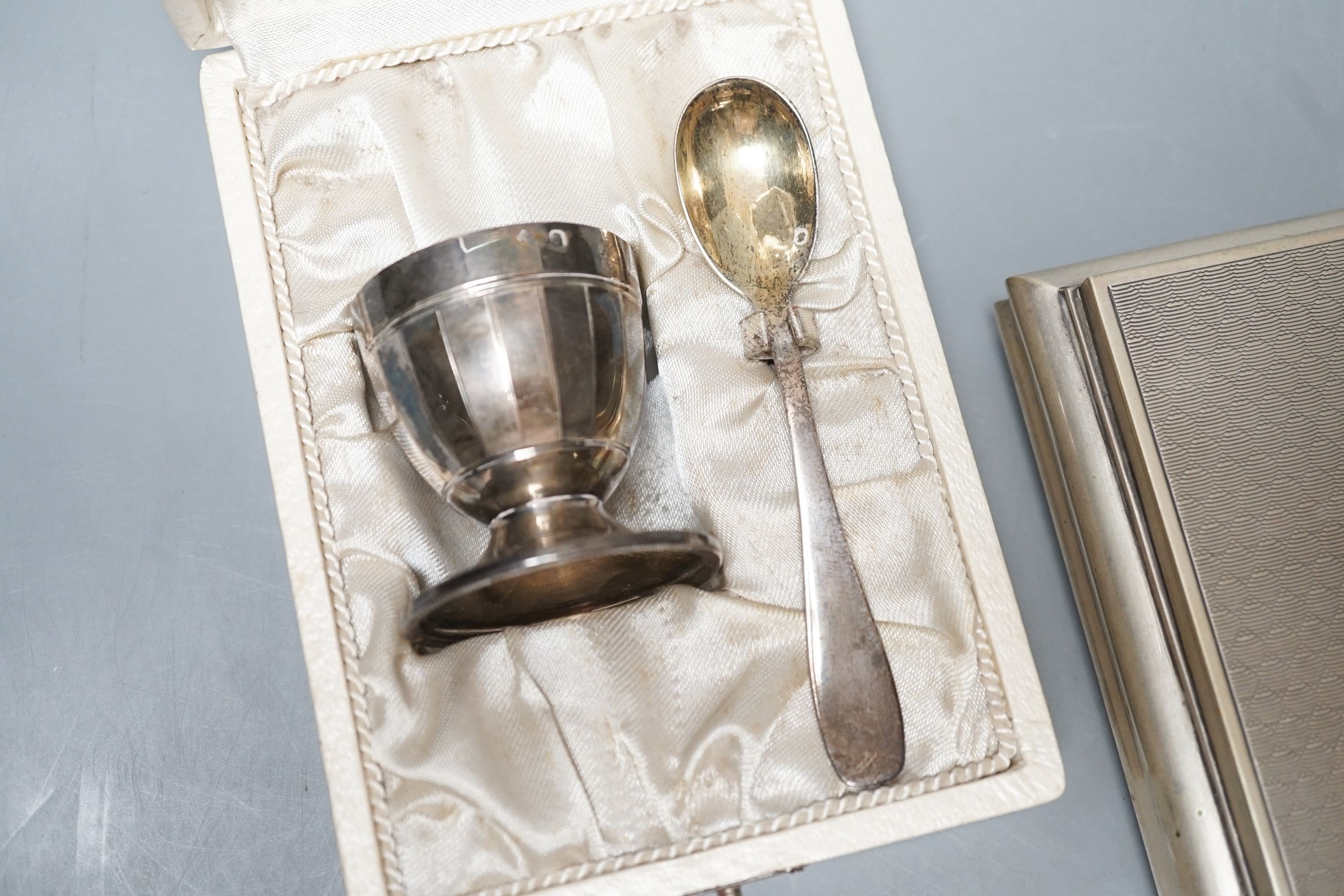 A modern Italian 800 standard white metal mounted cigarette box, 18.5cm and a cased French white metal egg cup and spoon.